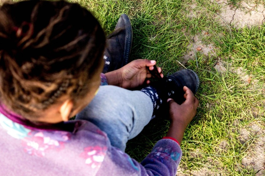 man in black jacket lying on grass field _