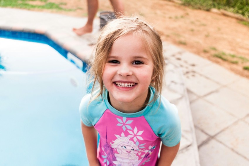 girl in white and pink floral crew neck t shirt smiling