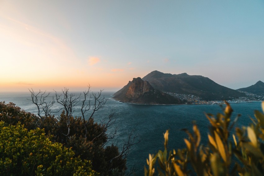 green mountain beside body of water during daytime