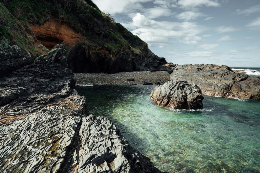 brown rock formation on body of water during daytime