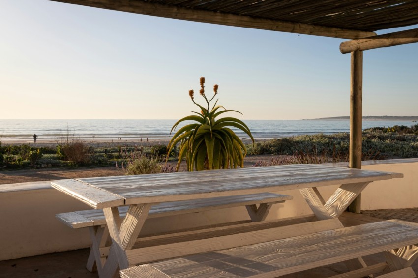 a white picnic table sitting under a pergolated roof