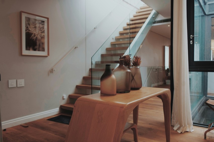 a table with vases on top of it next to a stair case