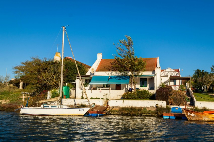 white and blue boat on water near white concrete building during daytime