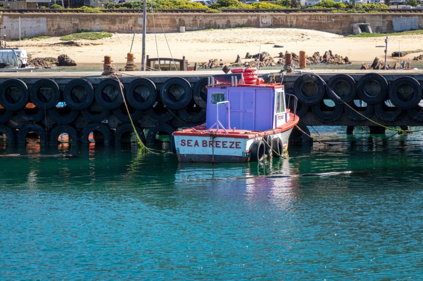 a small boat in the water near a dock