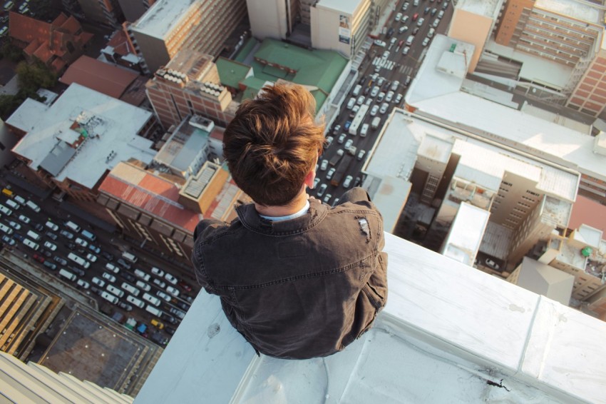 man in black jacket standing on top of building during daytime