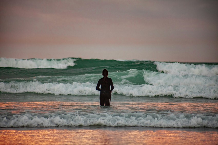 man in black wetsuit standing on sea shore during daytime rNcw