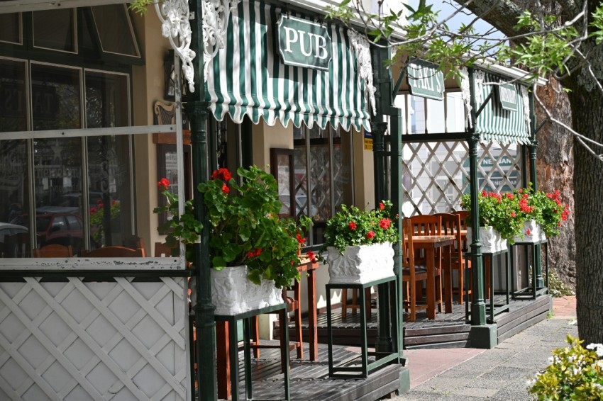 a building with a green awning and a table with flowers