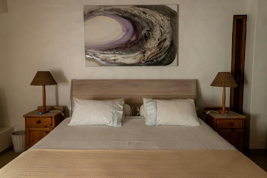 a bedroom with a large bed and a painting on the wall