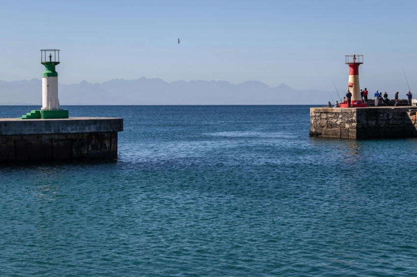 a light house sitting on top of a pier next to the ocean