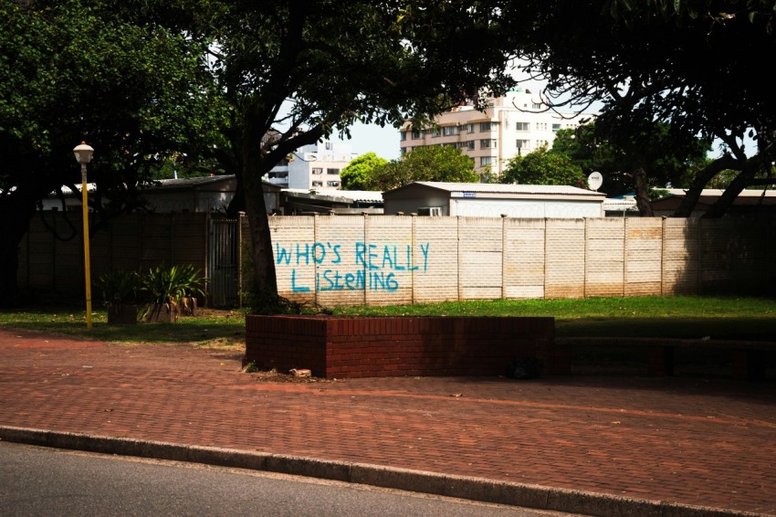 a sign that says whos really listening on the side of a building