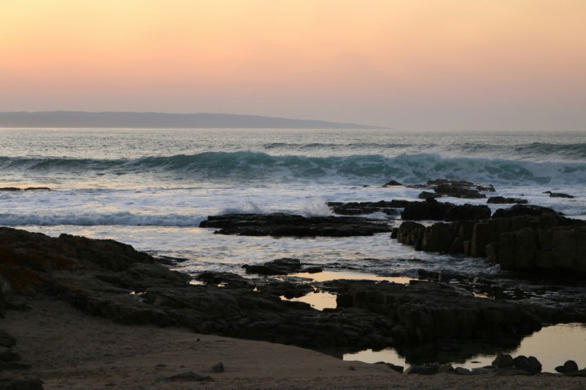 a person standing on a beach with a surfboard