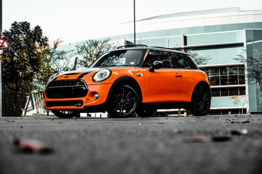 orange car on gray asphalt road during daytime ZSO