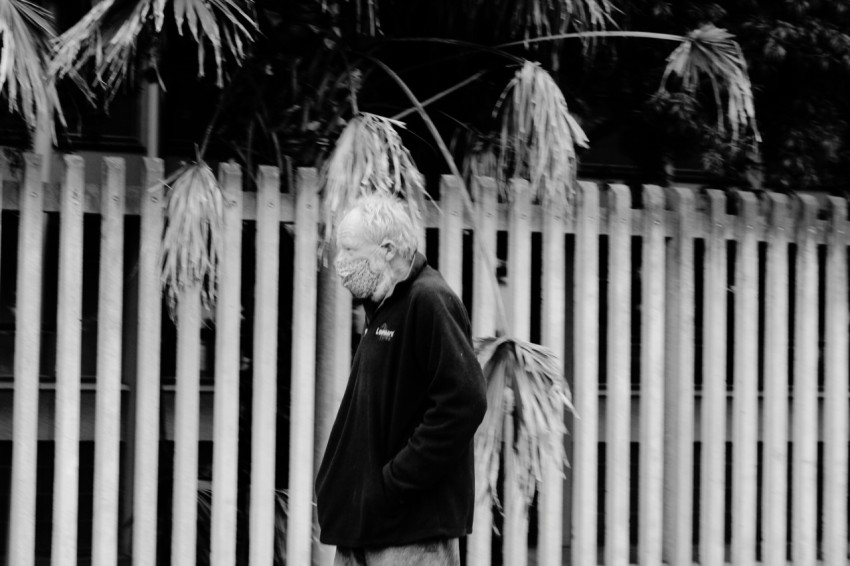 woman in black coat standing near fence