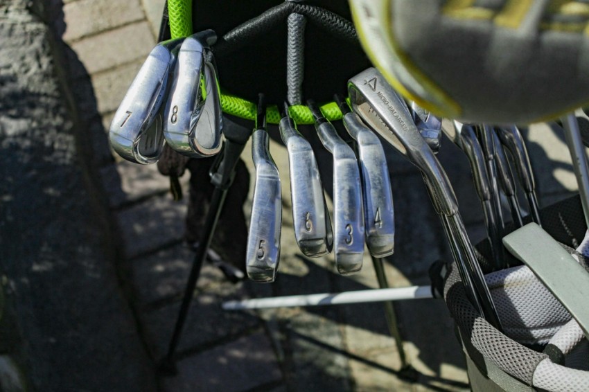 a bunch of golf clubs hanging from a rack