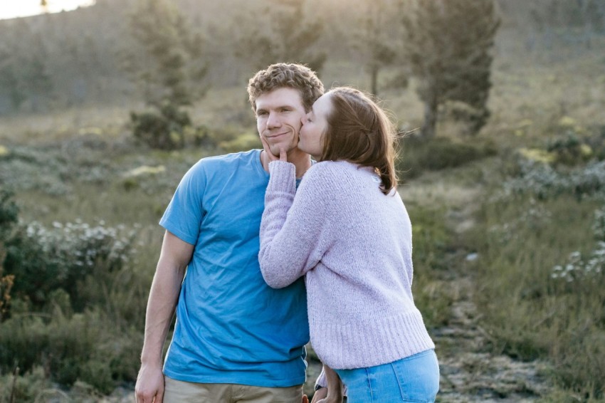 man in blue crew neck t shirt hugging woman in white long sleeve shirt 1