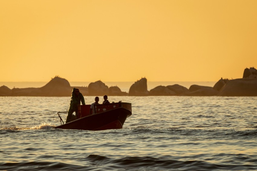 a group of people in a small boat in the water