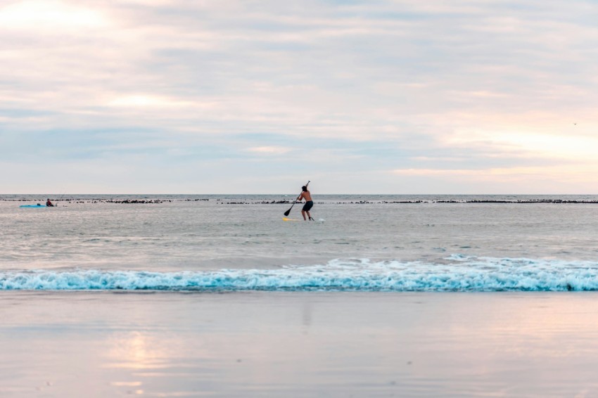 woman in black dress walking on beach during daytime gPF