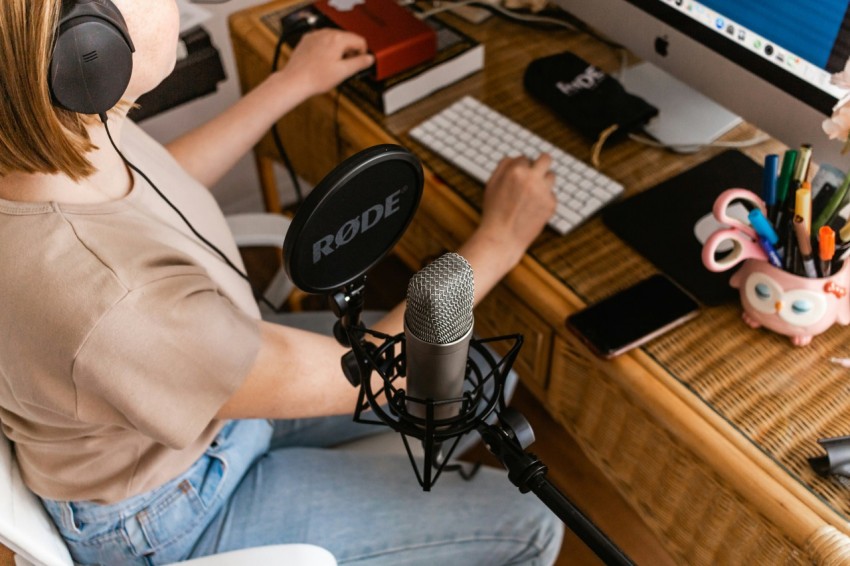 a woman sitting at a desk with a microphone in front of her