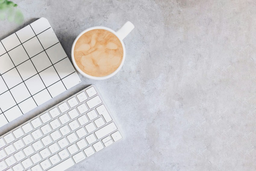 a cup of coffee next to a keyboard and mouse