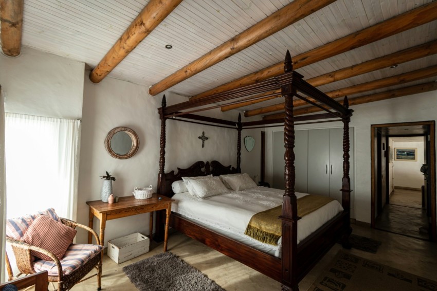 a bedroom with a four poster bed and a chair