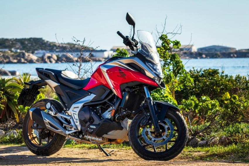 a red and black motorcycle parked on a dirt road