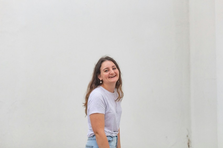 woman in white crew neck t shirt and blue denim shorts smiling