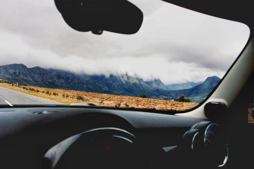 photo of car on road beside brown open field during cloudy daytime QT0q