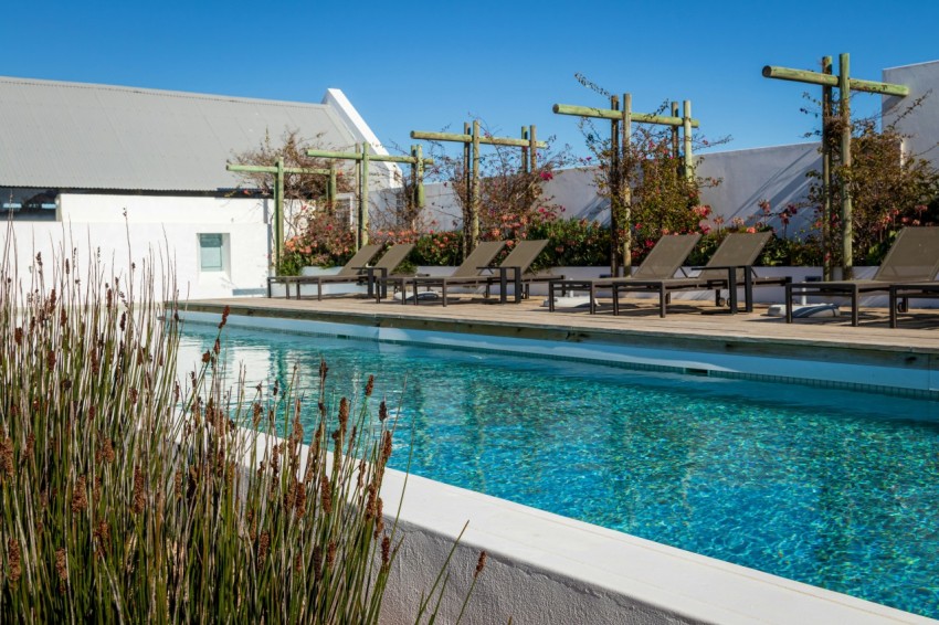 a large swimming pool with lounge chairs next to it