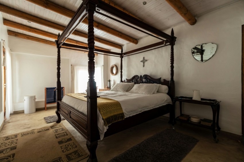 a bed sitting in a bedroom next to a window