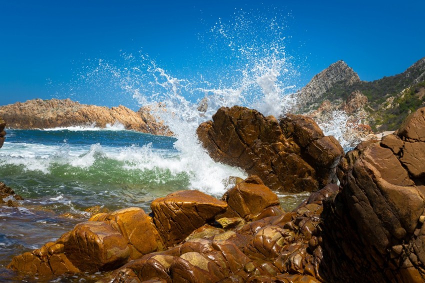 a rocky shore with waves crashing against the rocks