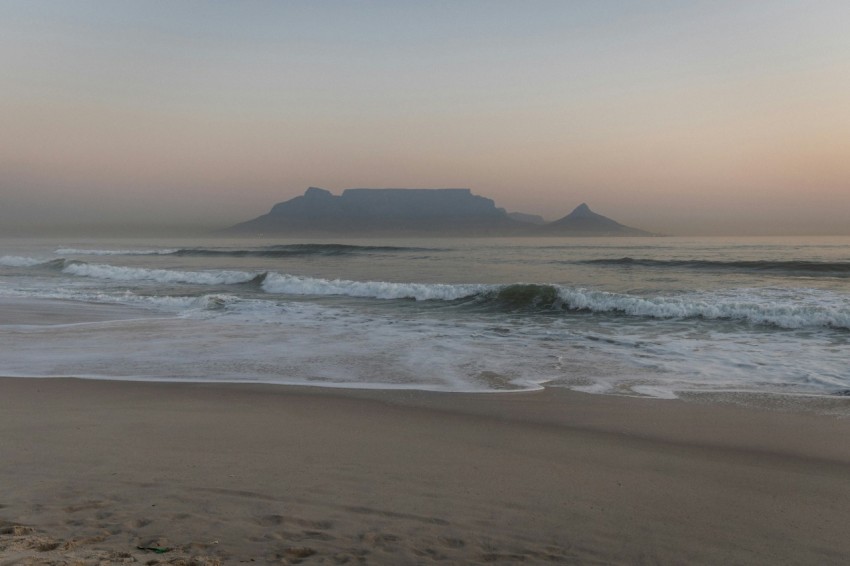 a blurry photo of a beach with waves coming in