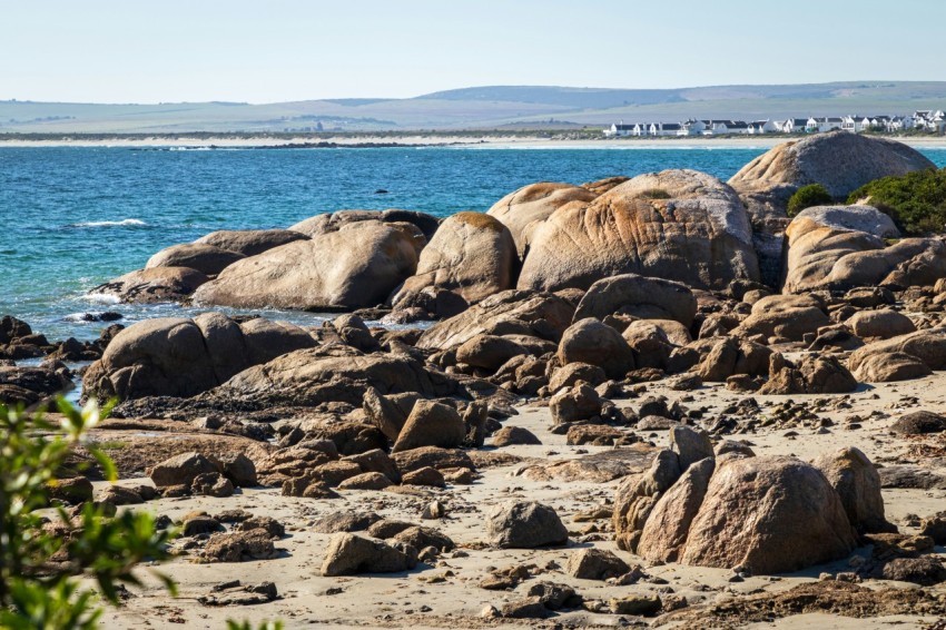 a rocky beach with a body of water in the background