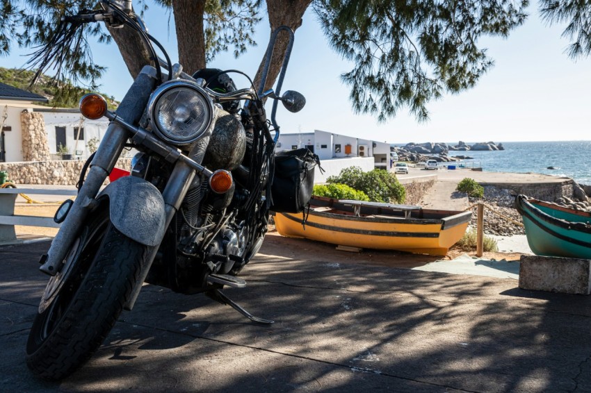 a motorcycle parked on the side of a road next to a tree