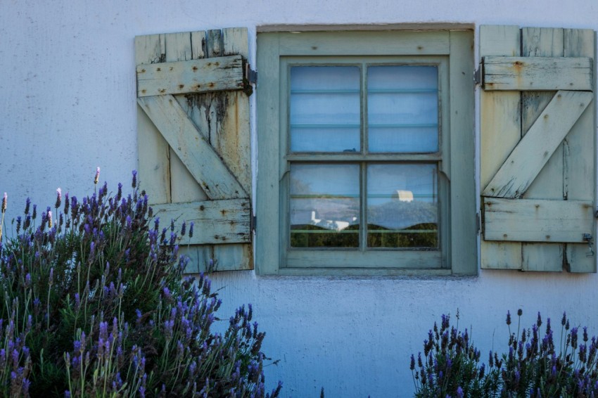 a window with shutters on a white building f