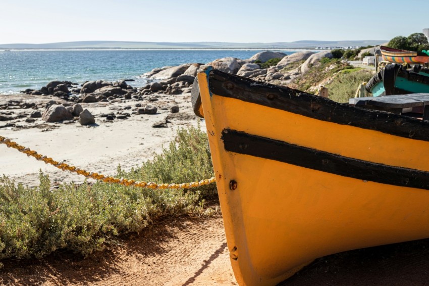 a yellow boat sitting on top of a sandy beach 5