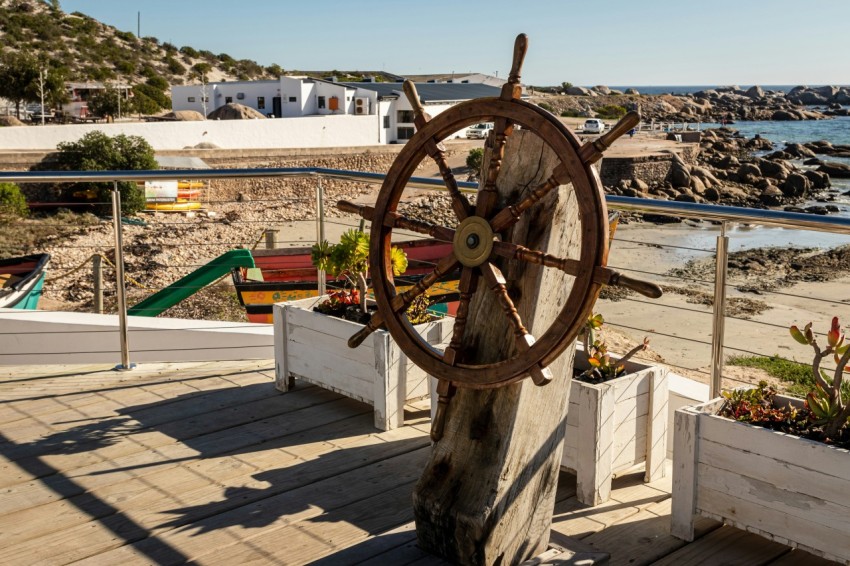 a boat wheel sitting on top of a wooden deck