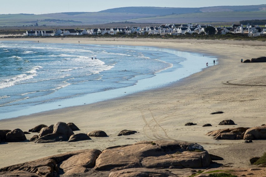 a view of a beach with houses in the distance 9SDpYe