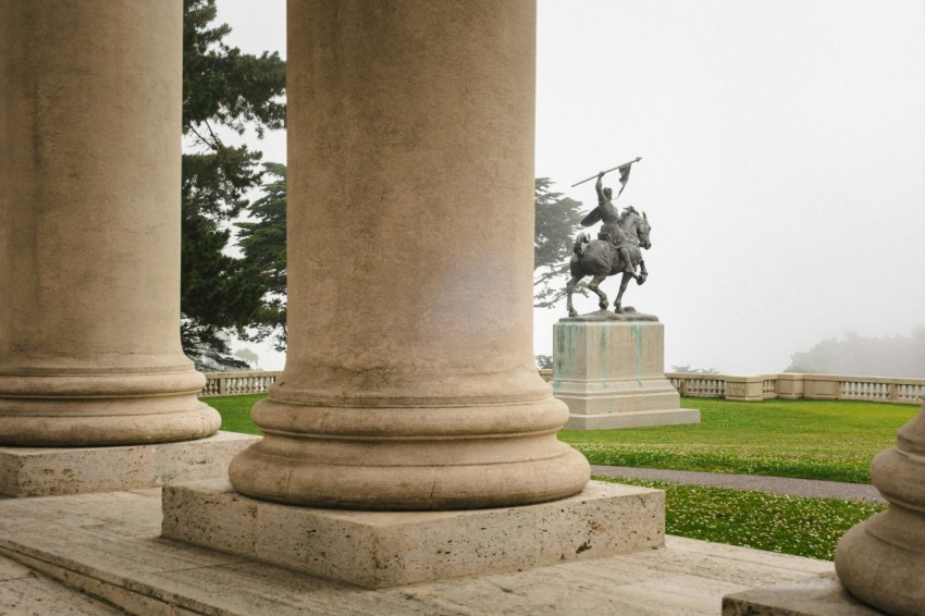 a statue of a man riding a horse on top of a green field