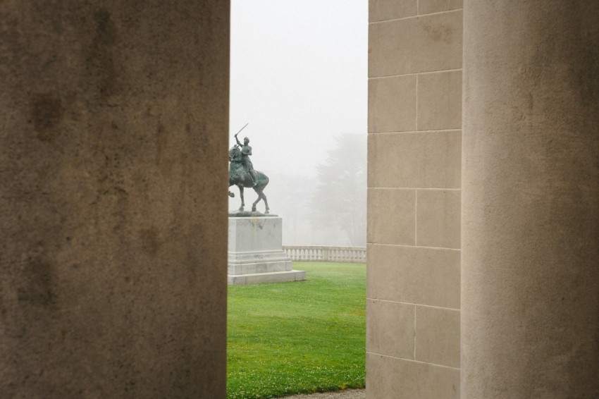 a view of a statue through two pillars