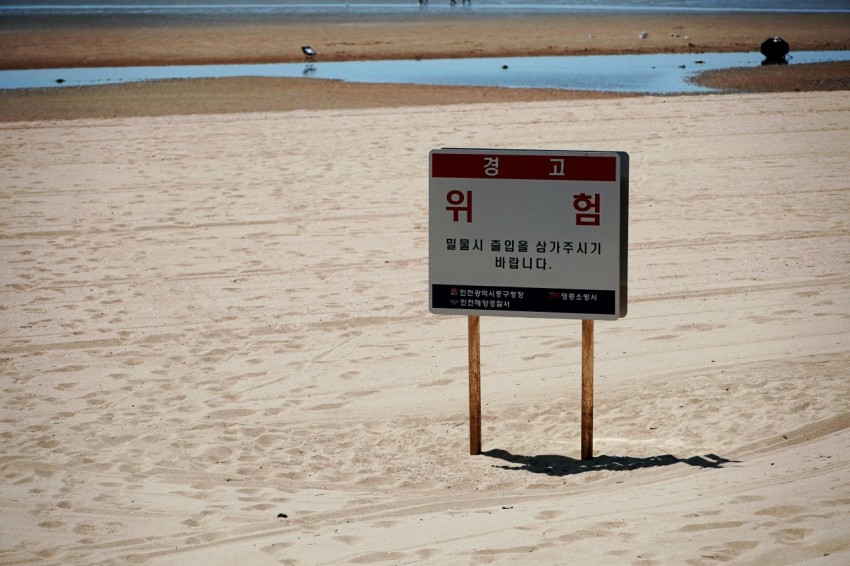 a sign in the sand on a beach