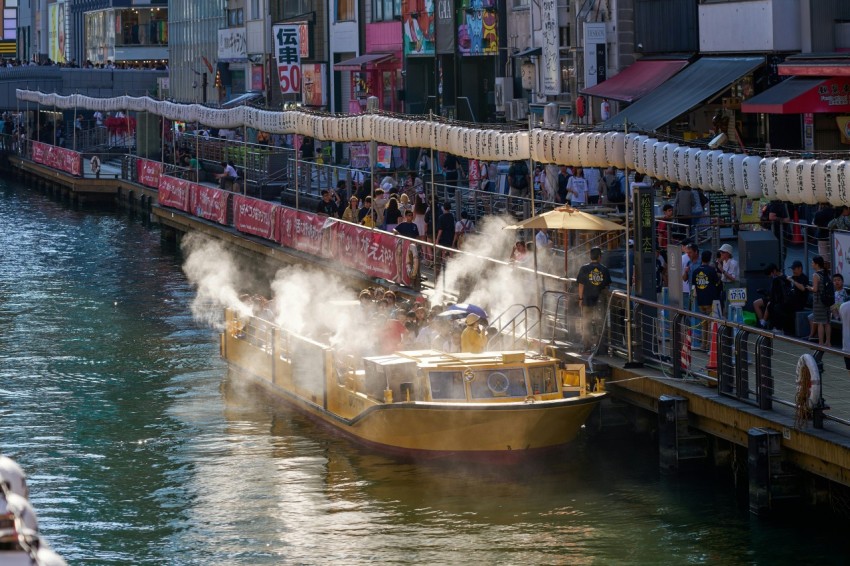 a boat traveling down a river next to a bridge