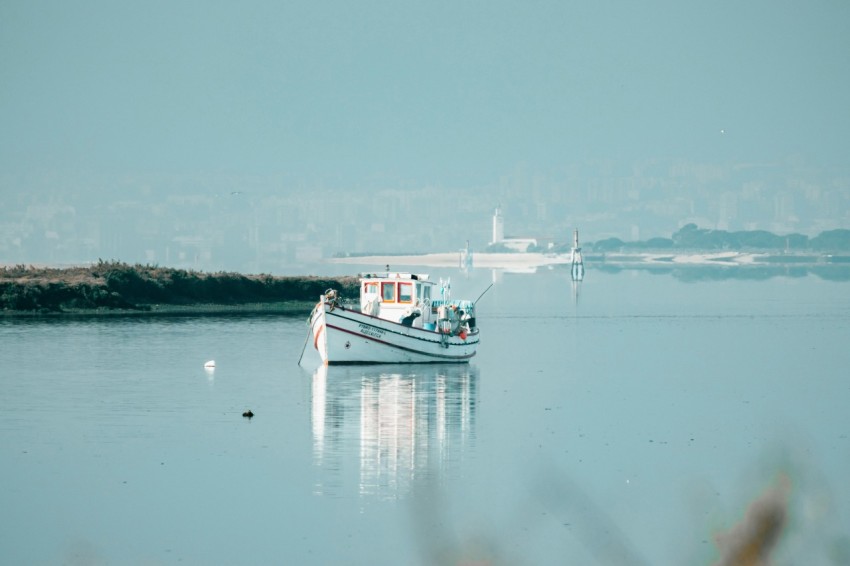 a small boat floating on top of a large body of water