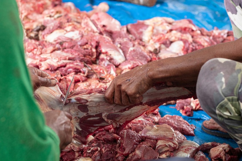 a man cutting meat with a knife on a table