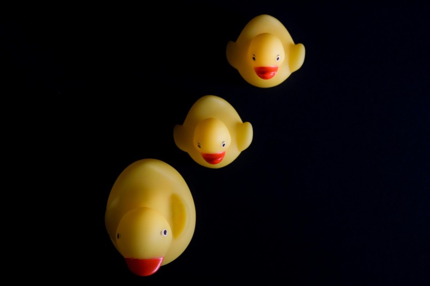 three rubber ducks sitting in a row on a table