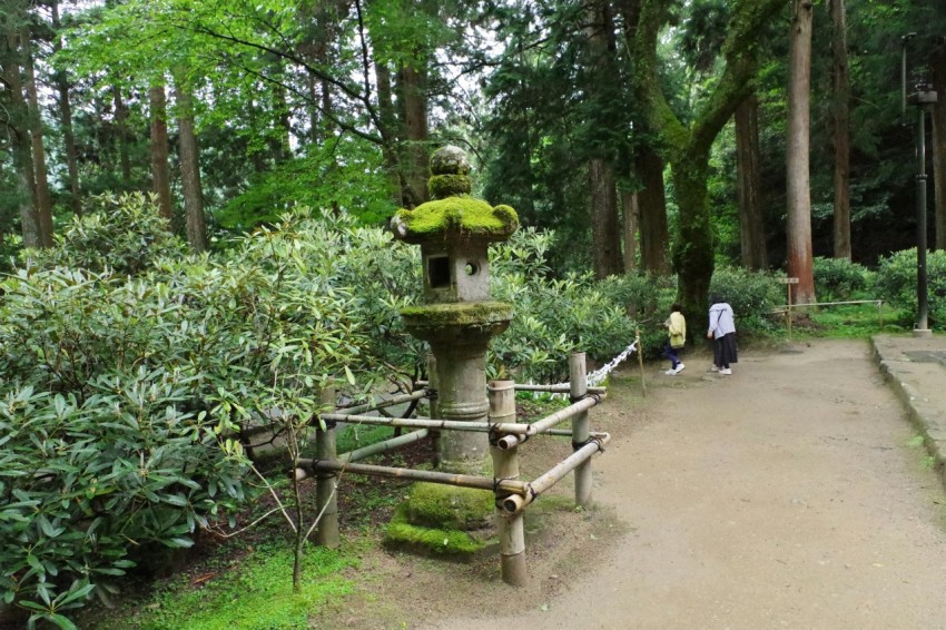 a stone water fountain in a park surrounded by trees aquYj1X5H