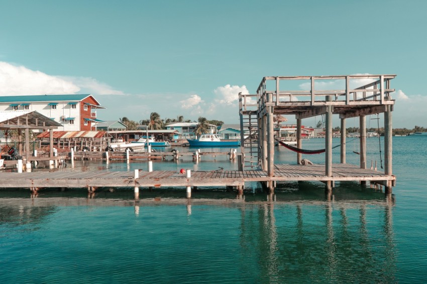 a dock with a house and a boat in the water