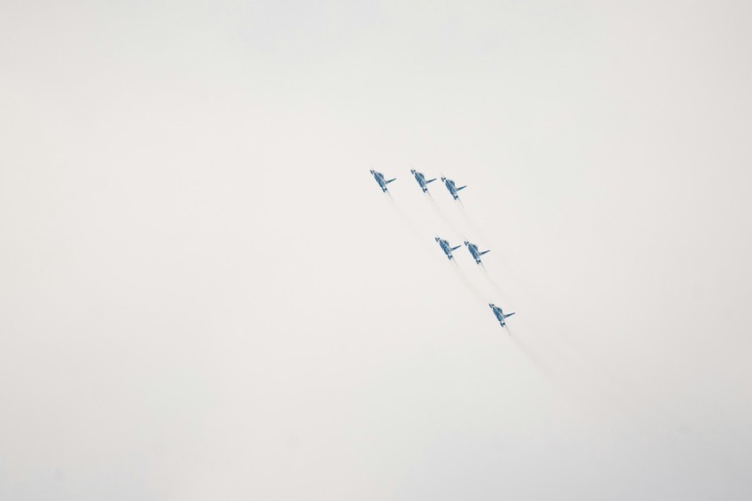 a group of fighter jets flying through a cloudy sky