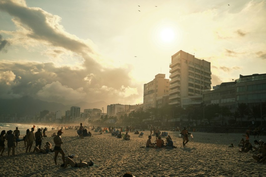 a group of people sitting on top of a sandy beach