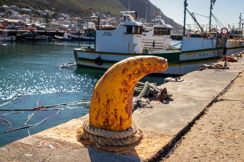 a large yellow object sitting on the side of a body of water