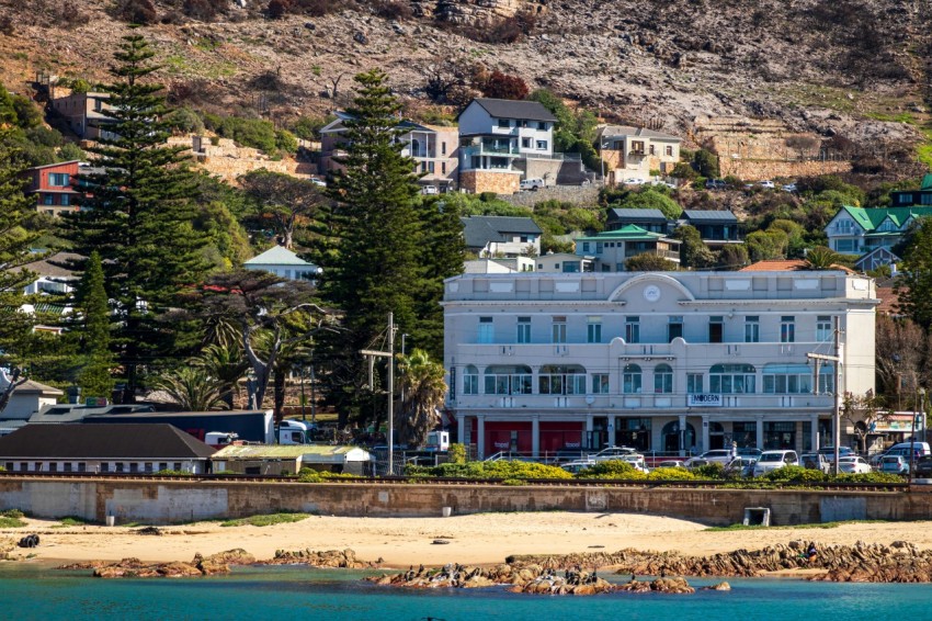 a large white building sitting on top of a lush green hillside